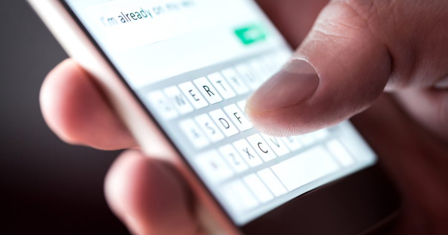 Man sending text message and sms with smartphone.