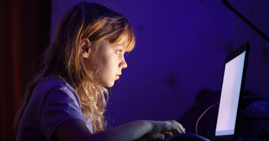 little blonde girl with a windows laptop at night